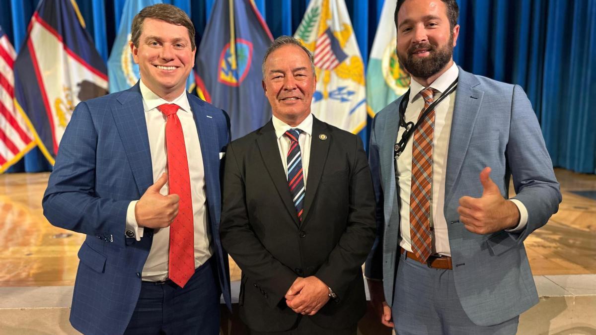 Rep. Moylan posing for photo with two men in suits