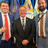 Rep. Moylan posing for photo with two men in suits